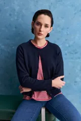 Cardigan de calce regular confeccionado en tejido de algodón y acrílico, color azul marino. Presenta cuello redondo, abertura frontal con botones y mangas largas con detalle de tejido en los hombros. Se completa con terminaciones acanaladas en puños y ruedo.