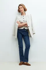 Chaleco sastrero color beige con rayas verticales negras, sin mangas y con cierre frontal con botones negros.