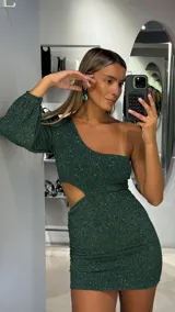 Vestido corto de lurex color verde esmeralda, con diseño de un solo hombro, manga larga abullonada y abertura lateral en la cintura. Presenta un ajuste al cuerpo con detalle fruncido en la falda.