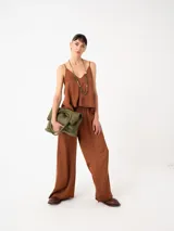 Top de viscosa color mostaza con escote en V y breteles finos regulables. Presenta un diseño minimalista de corte holgado y caída fluida.