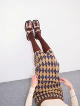 Guillerminas de estilo retro con punta cuadrada, confeccionadas en lona resistente con estampado de cuadros escoceses en tonos azul y beige. Presentan una correa fina ajustable sobre el empeine con hebilla metálica color bronce y un taco bajo de 4 cm.