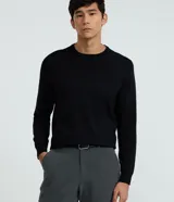 Suéter de manga larga y cuello redondo, color negro, con textura de punto. Corte regular.