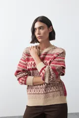 Sweater de punto con diseño jacquard de inspiración nórdica, cuello redondo y mangas largas. Presenta un patrón geométrico en tonos tierra, azul y blanco, con puños y ruedo acanalados.