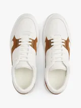 Zapatillas de corte bajo Tommy Hilfiger con diseño inspirado en el tenis, confeccionadas en piel napa blanca con paneles laterales de gamuza en color marrón. Presentan cierre con cordones, suela de goma y detalles de logo en bajo relieve.