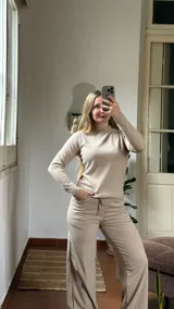 Pantalon de corte recto y holgado, confeccionado en tejido de punto acanalado color beige. Presenta cintura elástica con cordón ajustable y bolsillos laterales.