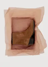 Botín de caña corta confeccionado en piel bovina, con diseño de punta fina y taco cuadrado de altura media.