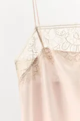 Vestido corto tipo lencero confeccionado en tejido satinado, con escote recto y tirantes finos ajustables. Presenta aplicaciones de encaje a contraste en el escote y en el ruedo.