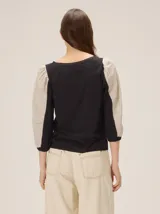 Blusa de diseño combinado con cuerpo delantero y espalda de algodón negro, y mangas abullonadas tres cuartos de lino en color beige con puños elásticos negros.