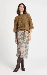 Sweater de punto color camel con diseño calado geométrico, cuello redondo y mangas largas con volumen suave. Presenta puños y dobladillo acanalados.