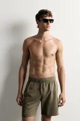 Short de baño largo en color beige, confeccionado en tejido técnico con tacto aterciopelado. Cuenta con cintura elástica ajustable con cordón, bolsillos laterales y detalle de bolsillo trasero, además de forro interior.