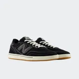 Championes New Balance Numeric 440 de estilo skate, color negro con costuras blancas visibles. Presentan el logo N en el lateral, cordones blancos y una suela de goma con entresuela color crema.