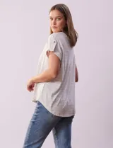 Remera gris a rayas horizontales blancas, con cuello a la base y escote en V. Manga corta con presilla y botón.