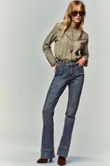 Camisa verde claro con cuello alto de puntilla, manga larga y detalles de entredoses calados en el pecho y los hombros. Cierre en la espalda con abertura y botón oculto.