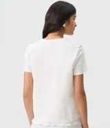 Remera blanca de algodón con cuello redondo, mangas cortas y estampa frontal con diseño tropical de palmeras y la inscripción "Fresh Air Salty Hair".