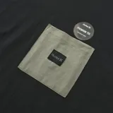 Remera Hurley de corte boxy, con cuerpo en color negro y mangas en color verde militar. Presenta un bolsillo frontal en el pecho en tono verde con etiqueta de la marca y cuello redondo.