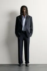 Blazer regular fit de lana color negro, con cuello de solapas de muesca, manga larga con botones en los puños y cierre frontal de botonadura. Cuenta con bolsillos de vivo en el pecho y de solapa en la cadera. Colección especial Aaron Levine x Zara.
