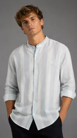 Camisa de lino de manga larga con cuello mao, diseño a rayas anchas en tonos celeste y blanco, y cierre frontal con botones.