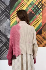 Saco de hilo con cuello alto y cierre de botones, de tejido de punto y diseño oversize. Presenta un teñido artesanal degradado que combina gris y beige, con mangas largas y puños amplios, además de un detalle de aplicación floral oscura en el pecho.