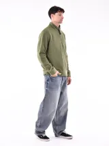 Buzo de polar color verde oliva, con cuello alto y cierre frontal parcial. Presenta puños y cintura acanalados.