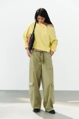 Sudadera de algodón con efecto lavado en color amarillo, cuello barco, abertura frontal con botones a presión y manga larga.