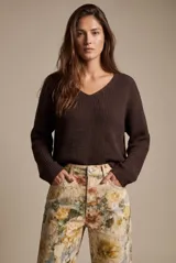 Sweater de punto color marrón, con escote en V y mangas largas de diseño holgado.