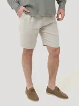 Short de lino orgánico color beige, con ajuste de cordón en la cintura, bolsillos laterales y traseros, y corte relajado.