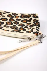 Neceser con estampado animal print de leopardo en tonos beige, marrón y negro. Cuenta con cierre superior y correa de mano.