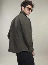 Campera casual liviana de nylon, con cierre frontal de botones a presión, cuello camisero y bolsillos frontales tipo parche.