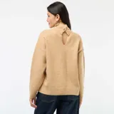 Suéter de punto con cuello alto, diseño de corte holgado y mangas largas con puños acanalados.