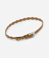 Cinturón estilo boho color tostado, con diseño de bordes ondulados y aplicaciones de tachas metálicas circulares. Cuenta con hebilla metálica de estilo western y múltiples perforaciones para ajuste.