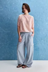 Pantalón cargo celeste de tiro alto y pierna amplia, con bolsillos laterales y bolsillos cargo con tapa.