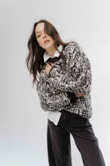 Buzo de tejido grueso con diseño artesanal bicolor, cuello redondo y terminaciones en rib en puños y cintura. Presenta un calce relajado y cómodo.