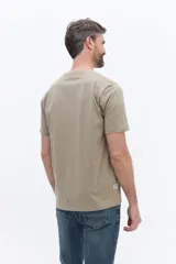 Remera de manga corta color beige con cuello redondo y calce regular. Presenta un estampado con lettering en el pecho.