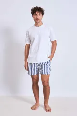 Short de baño con estampado botánico en tonos tierra, rosados y verdes. Presenta cintura elástica con cordón ajustable y un pequeño parche con logo en el ruedo.