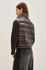 Campera híbrida con frente acolchado tipo puffer en color negro y mangas de tejido liso al tono. Presenta cuello alto, cierre frontal y diseño entallado.