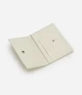 Billetera tipo sobre pequeña de color beige con textura croco en relieve y cierre con solapa y botón a presión.