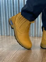 Botín marrón de cuero con elásticos laterales, suela de goma color caramelo y puntera reforzada.