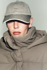 Campera puffer corta de tejido engomado resistente al viento, con aislamiento térmico. Presenta cuello subido con capucha, manga larga, bolsillos delanteros y bajo ajustable con stoppers laterales. Cierre frontal con cremallera termosellada y botones magnéticos.