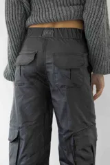 Pantalón cargo colorado de tela brillante con elástico en la cintura y bolsillos con solapa.