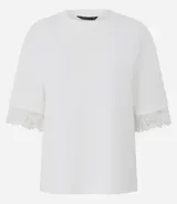 Remera de corte recto y calce confortable, confeccionada en algodón. Presenta cuello redondo y mangas cortas amplias con delicada aplicación de encaje en los bordes.