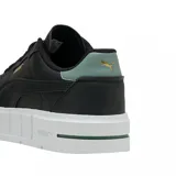 Championes Puma modelo Cali Court, color negro con suela de plataforma blanca. Presenta detalles en verde pastel en el talón y logo de la marca en dorado en el lateral y la lengüeta.