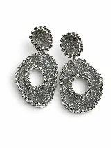 Aros colgantes dorados con apliques de strass, compuestos por una pieza superior circular texturizada y una pieza inferior ovalada con abertura central.
