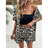 Conjunto de dos piezas compuesto por una camisa de manga corta con cuello italiano y cierre frontal de botones, y un short con cintura elástica y bolsillos laterales. Ambas prendas presentan un diseño estampado de animal print.