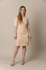 Vestido corto color beige con detalle drapeado en la cintura y hombros descubiertos.