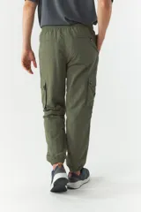Pantalón cargo gris de nylon con cintura ajustable, bolsillos laterales con solapa y puños elásticos.