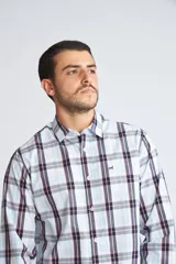 Camisa de manga larga con cuello clásico y cierre frontal abotonado. Presenta un estampado de cuadros en tonos azul marino y rojo. Confeccionada en algodón, cuenta con un corte slim fit y logo bordado en el pecho.