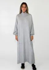 Vestido largo de punto, con cuello alto y mangas largas holgadas. Diseño de corte recto y estilo minimalista.