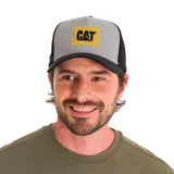 Gorro de camionero gris con visera y laterales negros. Presenta logo de Caterpillar bordado en amarillo y negro sobre un parche cuadrado con rayas horizontales amarillas.