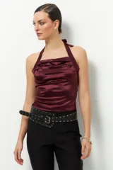 Top negro de satén con cuello halter y espalda descubierta.