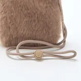 Bolso bandolera pequeño para teléfono, confeccionado en piel sintética de pelo largo color gris topo. Cuenta con una solapa frontal de cuero sintético liso y correa fina ajustable.